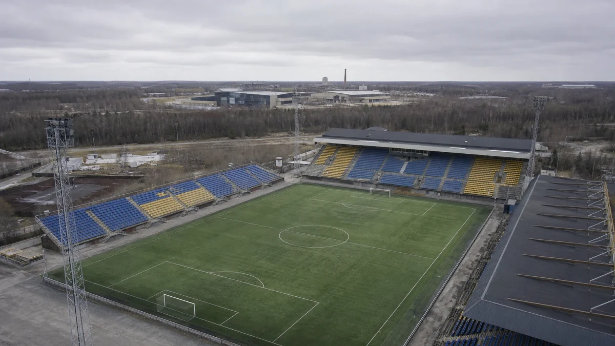 Fotboll på gräset i en tom kvällsbelyst arena