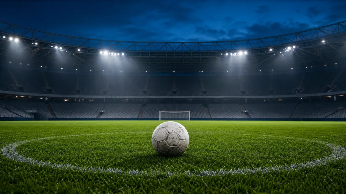 Fotboll på gräset i en tom kvällsbelyst arena