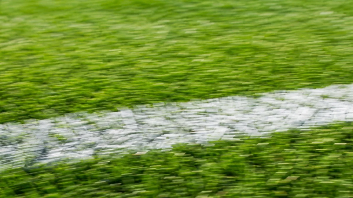 Fotboll på mittlinjen på en tom plan i skymningsljus